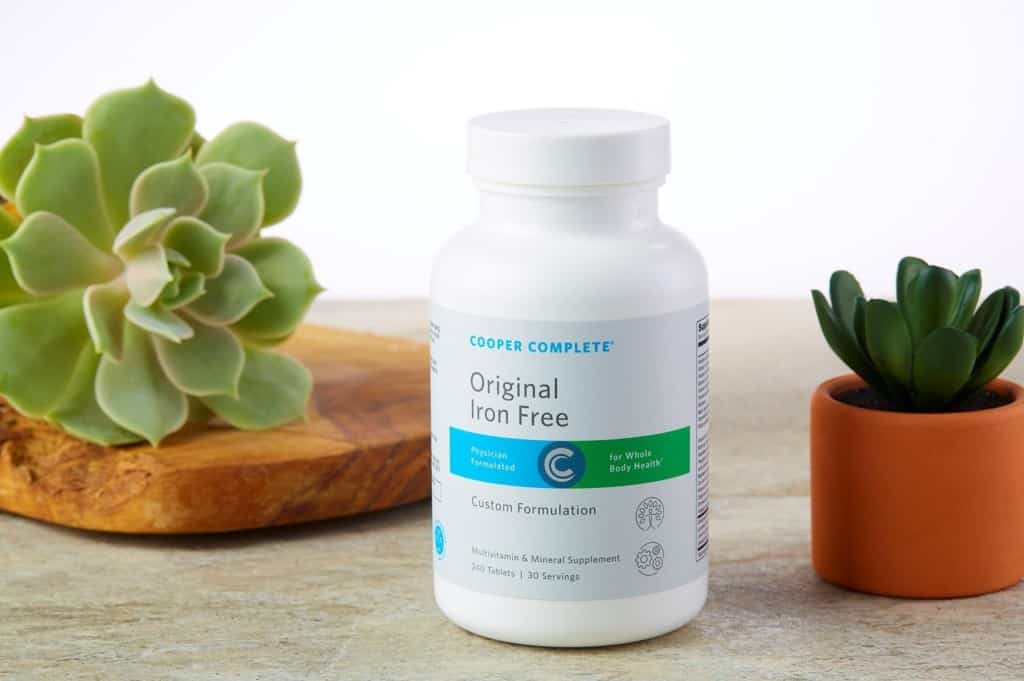 Cooper Complete Original Iron Free multivitamin and mineral formulation bottle with succulents on a counter