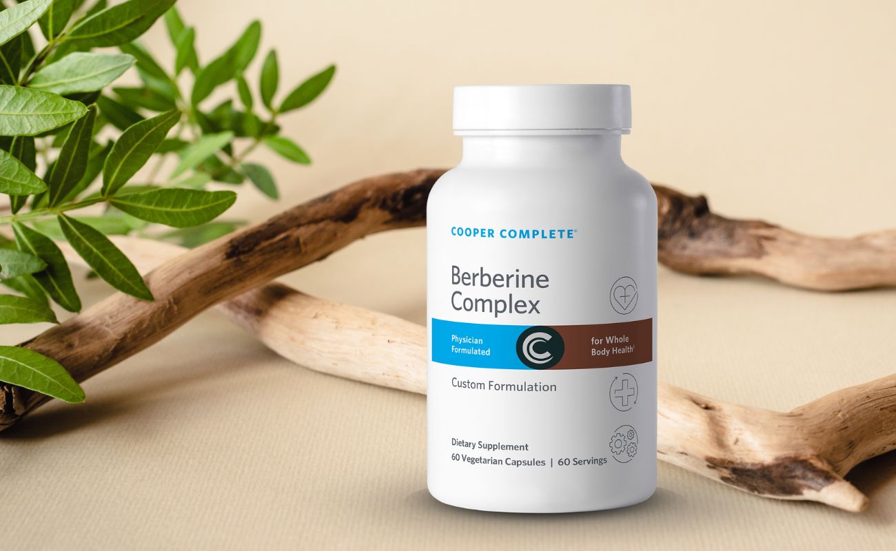 Photo of Cooper Complete Berberine Supplement bottle surrounded by organic wood and greenery