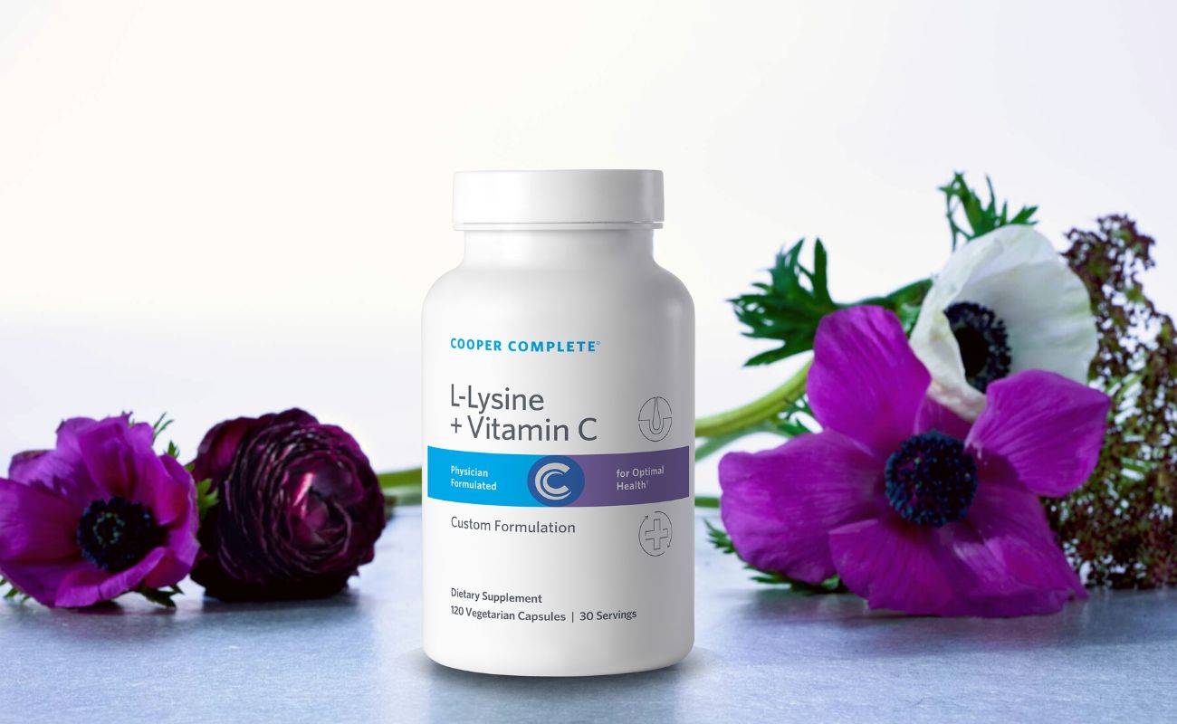 Photo of Cooper Complete L-Lysine Supplement 1500 mg bottle surrounded by beautiful flowers