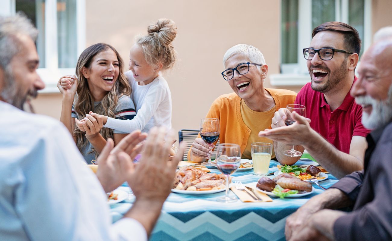 Photo of a multigenerational family on the patio enjoying dinner.