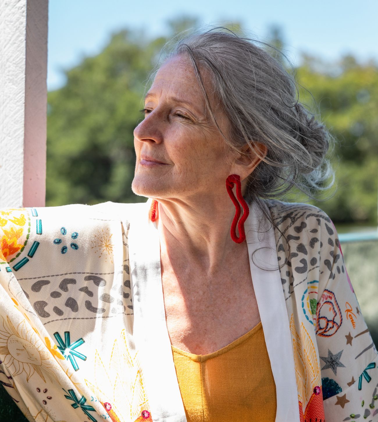 Photo of an older hippy woman enjoying the outdoors.