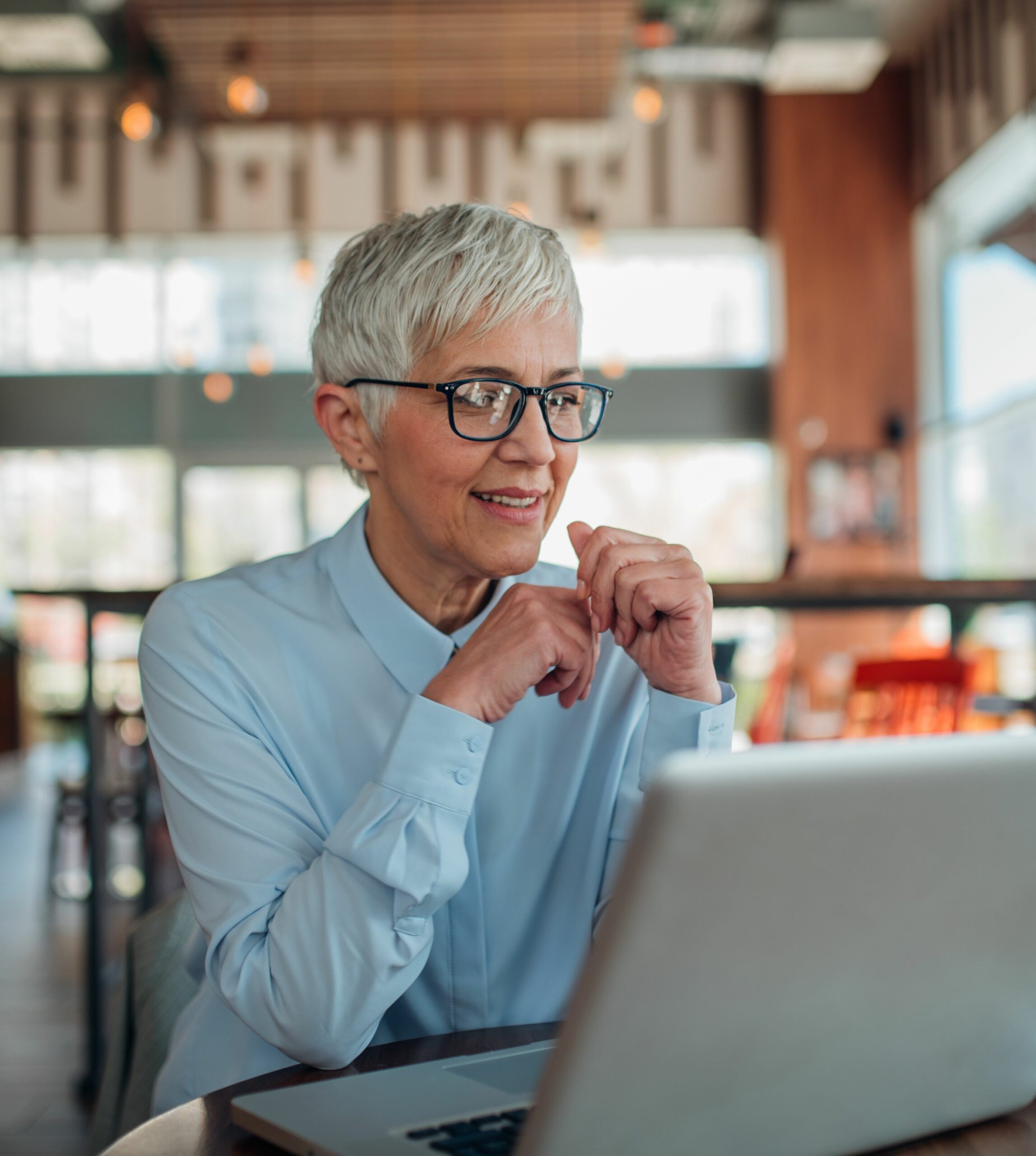 Photo of a mature woman working on her laptop in an empty public space