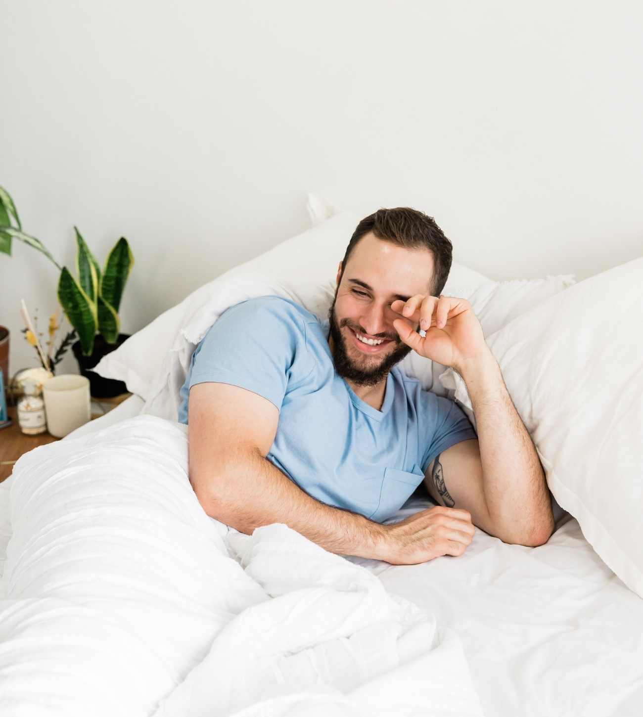 Man smiling and waking up in bed.